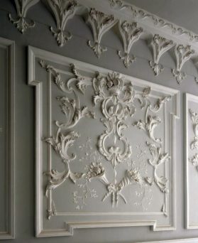 Detail of the plaster panel on the wall of the Inner Hall at Florence Court. The pattern includes many flowers and leaves in white.