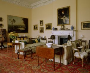 Drawing Room at Florence Court. The chimneypiece is neoclassical Carrara marble with Ionic columns & elaborate frieze. The room is filled with Enniskillen family portraits and furnishings.
