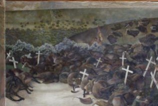 Oil painting on canvas, The Resurrection of the Soldiers by Sir Stanley Spencer, CBE, RA (Cookham 1891? Cliveden 1959), 1928/9. This picture is a reminder of the relationship between war, death and Christianity. The 'Resurrection' took Spencer nearly a year to complete. It dominates the Chapel and all the other scenes are subordinate too it. The picture is a reminder of the relationship between war, death and Christianity, not merely a convenient and familiar religious image behind the altar. The composition is based on a complex pattern of wooden crosses which was suggested to Spencer by his habit of squaring up the canvas in order to work out the design. As a living soldier hands in his rifle at the end of service, so a dead soldier carries his cross to Christ, who is seen in the middle distance receiving these crosses. Spencer's idea was that the cross produces a different reaction in everybody.